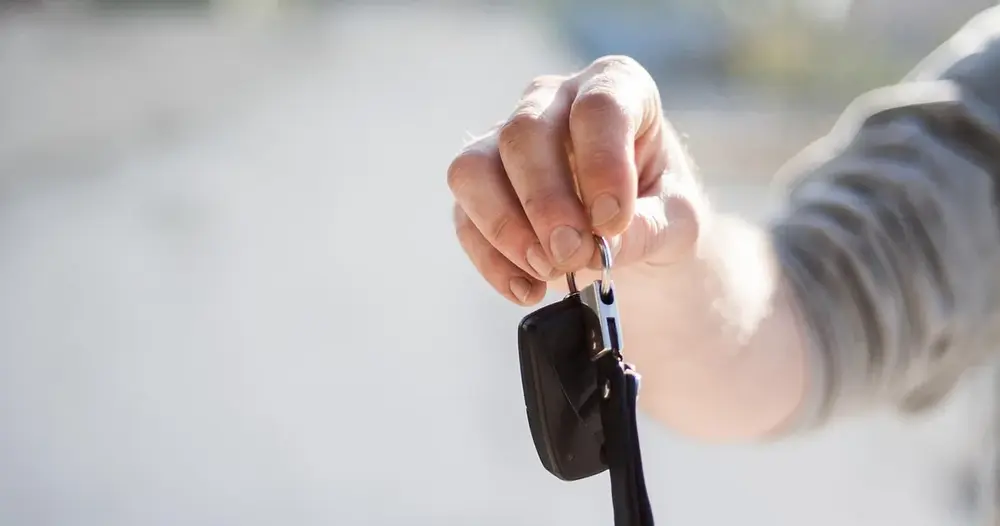 Mão segurando a chave de um carro, cena de compra de carro com débitos no Ceará a conferir antes do negócio